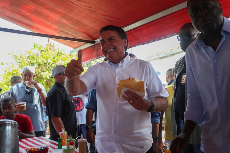 Bolsonaro come pastel após votar Bolsonaro come pastel após votar