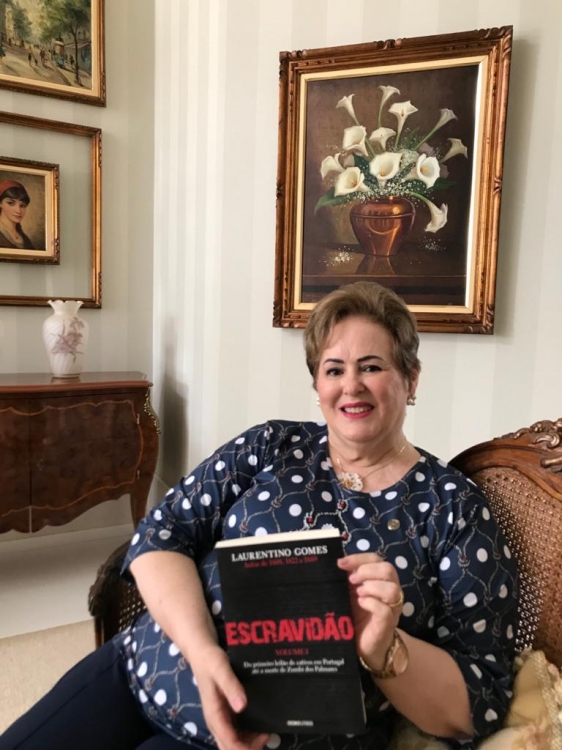 Amelinha Freitas, empresária, com o livro Escravidão, de Laurentino Gomes